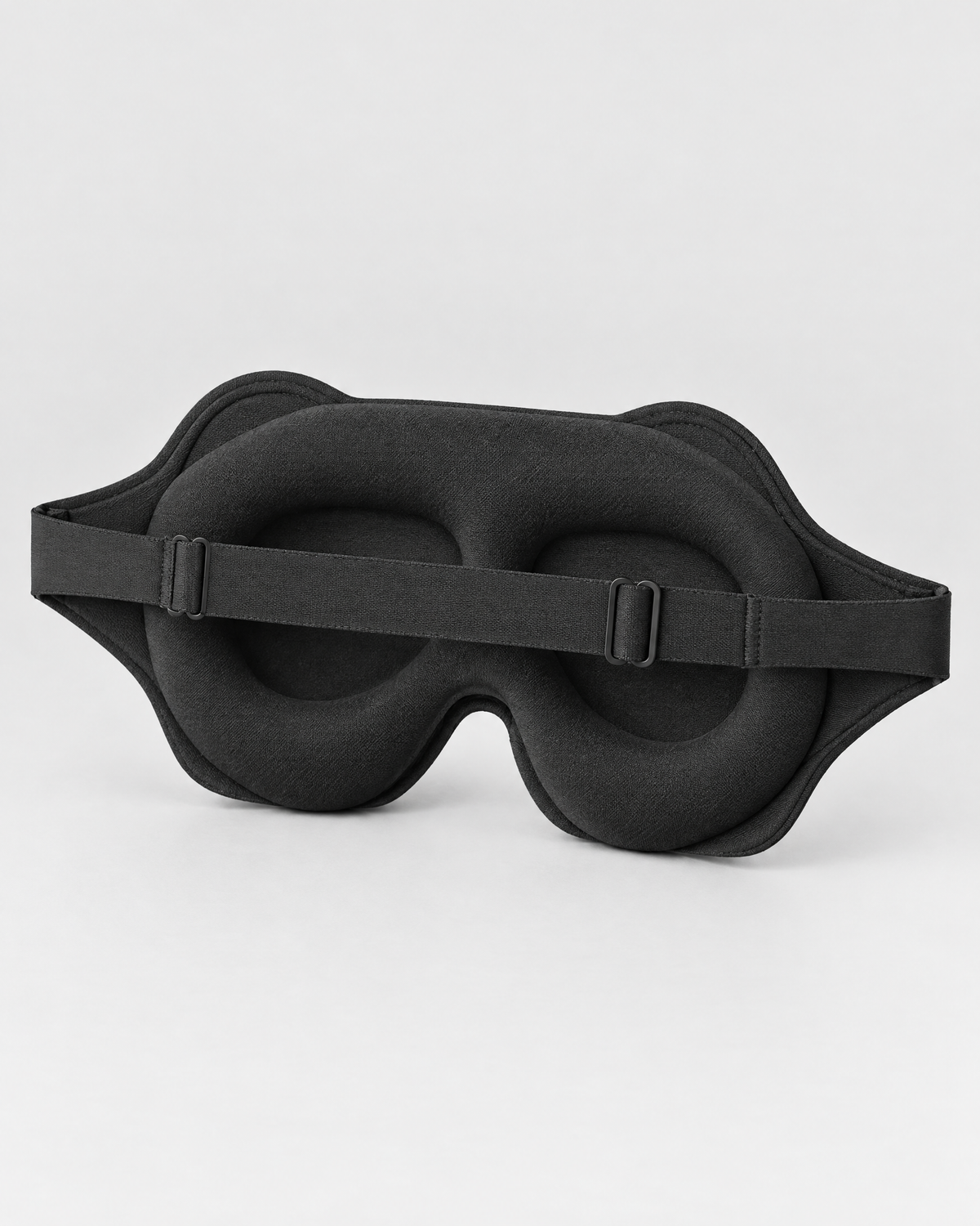 Inside of the mask: two eye cavities, cushioned border, nose flaps and strap with two sliders