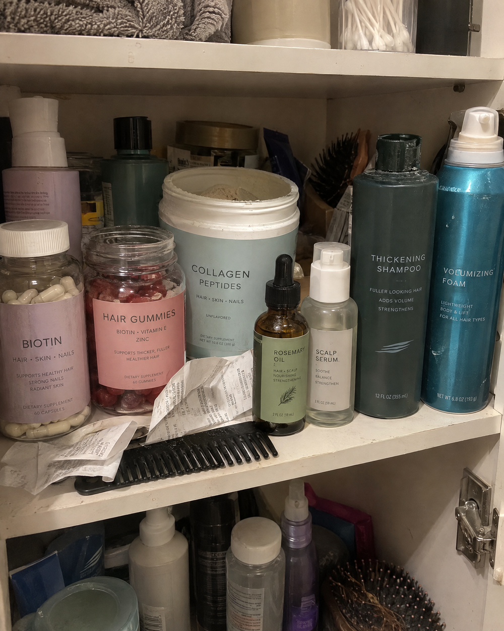 Bathroom shelf crowded with half-used hair products