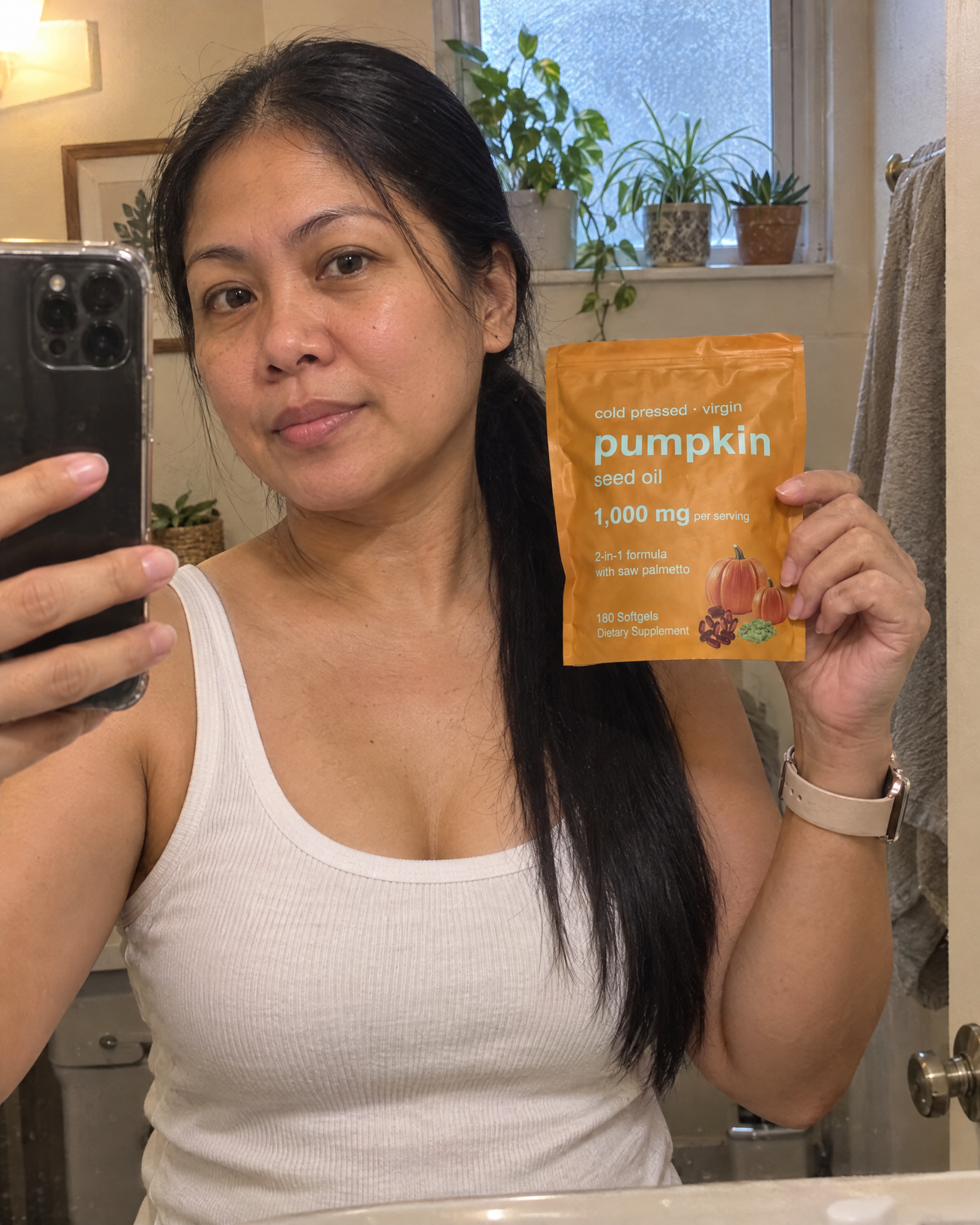 Woman holding the pouch in a bathroom mirror selfie